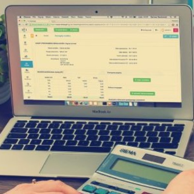 laptop with white background containing table data and a calculator being used to calculate legal costs for billing,